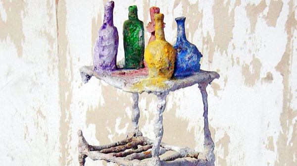 CINCO BOTELLAS SOBRE MESA TV, hierro fundido pintado y granito, 41 x 23 x 21 cm